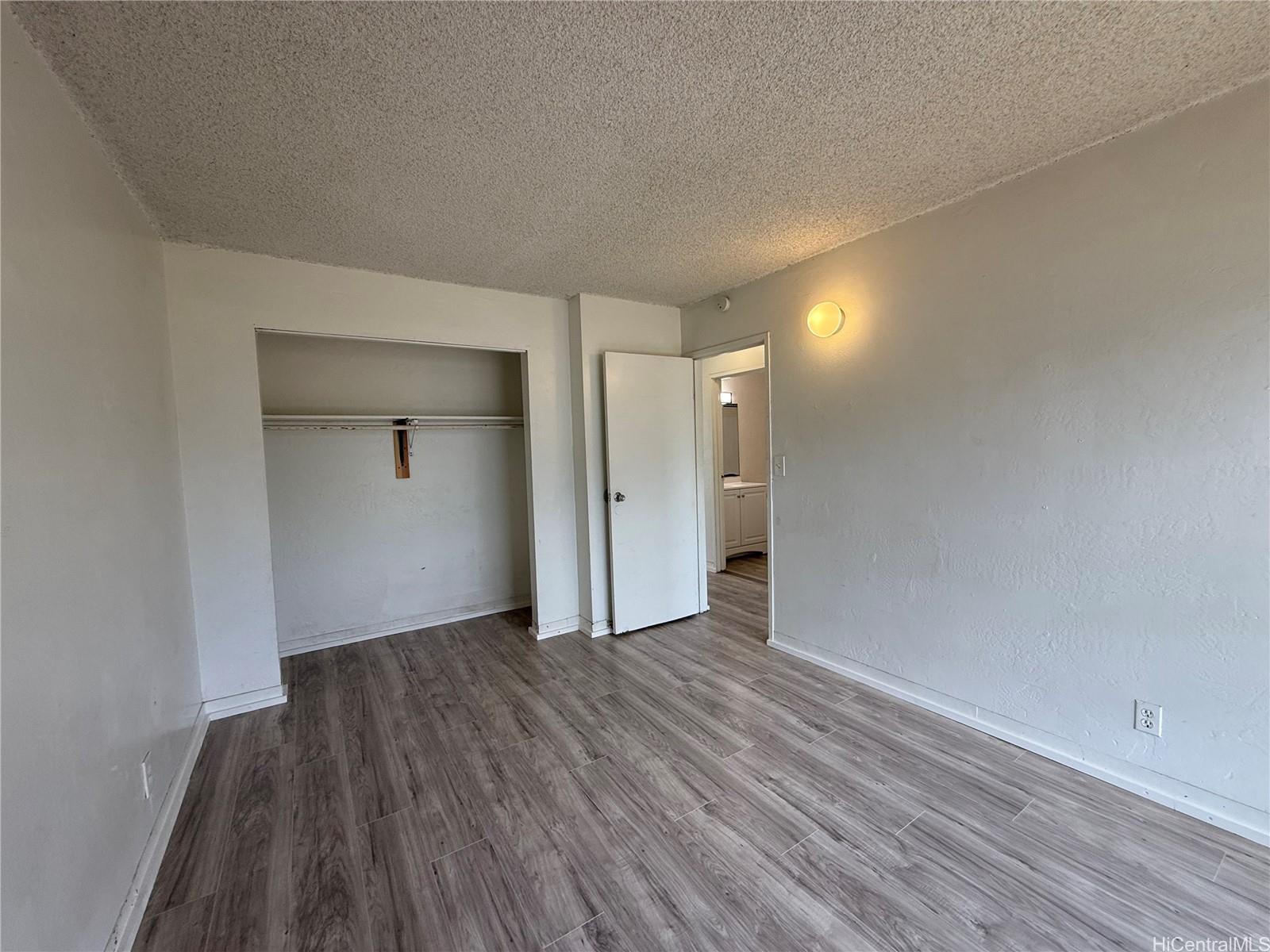 87-134 Helelua Street, Unit A302 Waianae, HI 96792 - Photo 6 of 16 a view of an empty room with wooden floor and closet