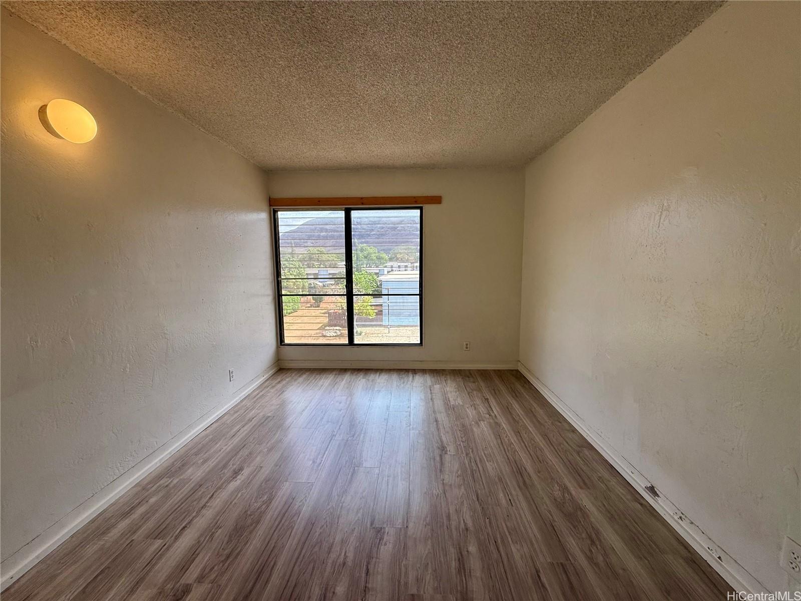 87-134 Helelua Street, Unit A302 Waianae, HI 96792 - Photo 7 of 16 an empty room with wooden floor and windows