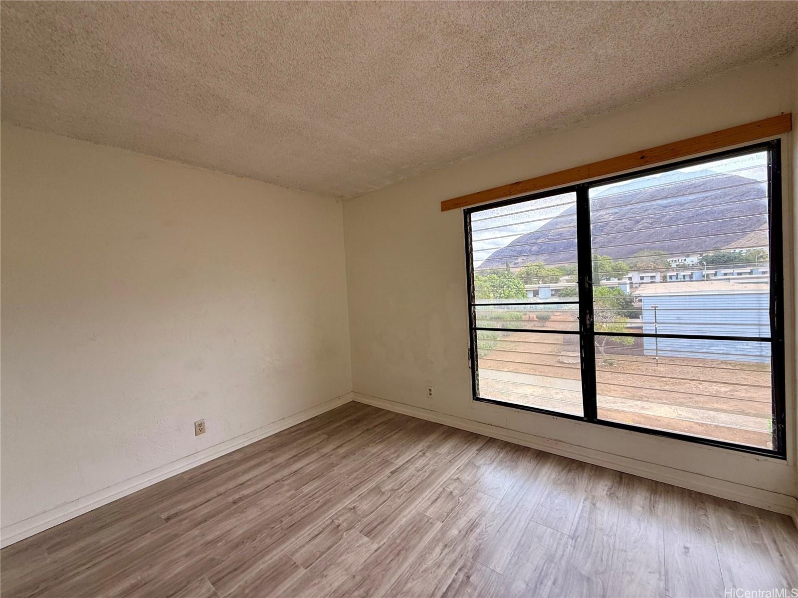 87-134 Helelua Street, Unit A302 Waianae, HI 96792 - Photo 8 of 16 wooden floor in an empty room with a window