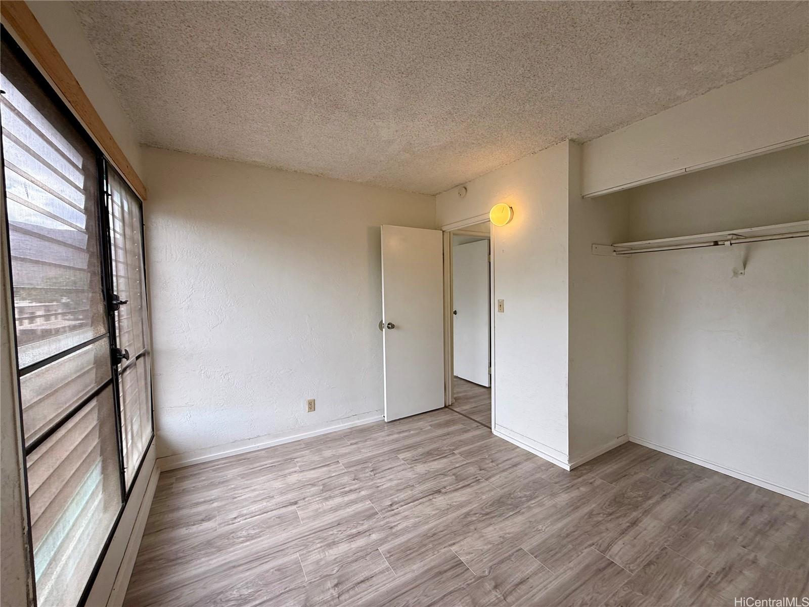 87-134 Helelua Street, Unit A302 Waianae, HI 96792 - Photo 9 of 16 a view of empty room with wooden floor and fan