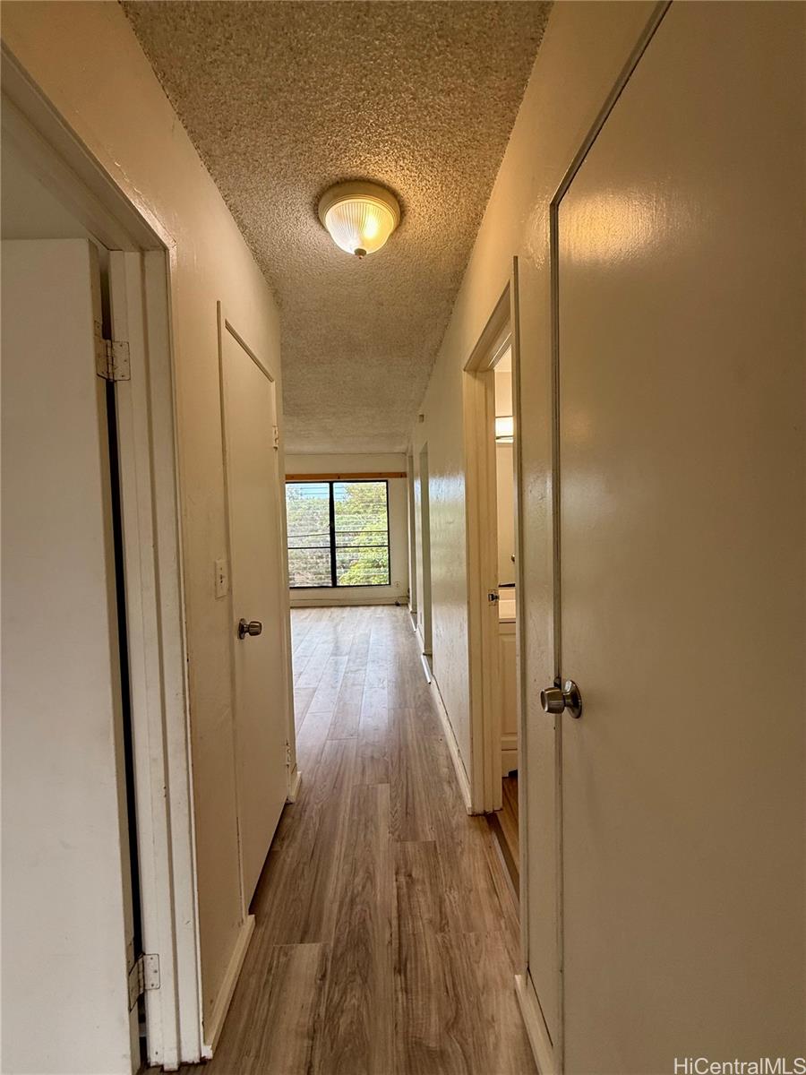 87-134 Helelua Street, Unit A302 Waianae, HI 96792 - Photo 10 of 16 a view of a hallway with wooden floor and a bathroom