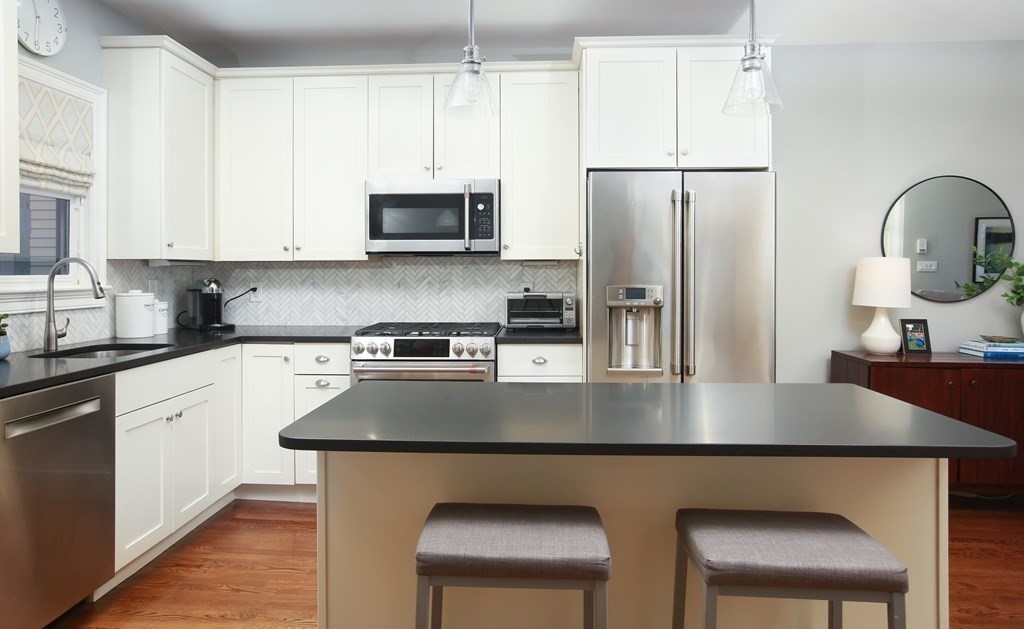 62 Sullivan Street, Unit 1 Boston, MA 02129 - Photo 3 of 11 a kitchen with stainless steel appliances granite countertop a stove a refrigerator a sink a stove and white cabinets