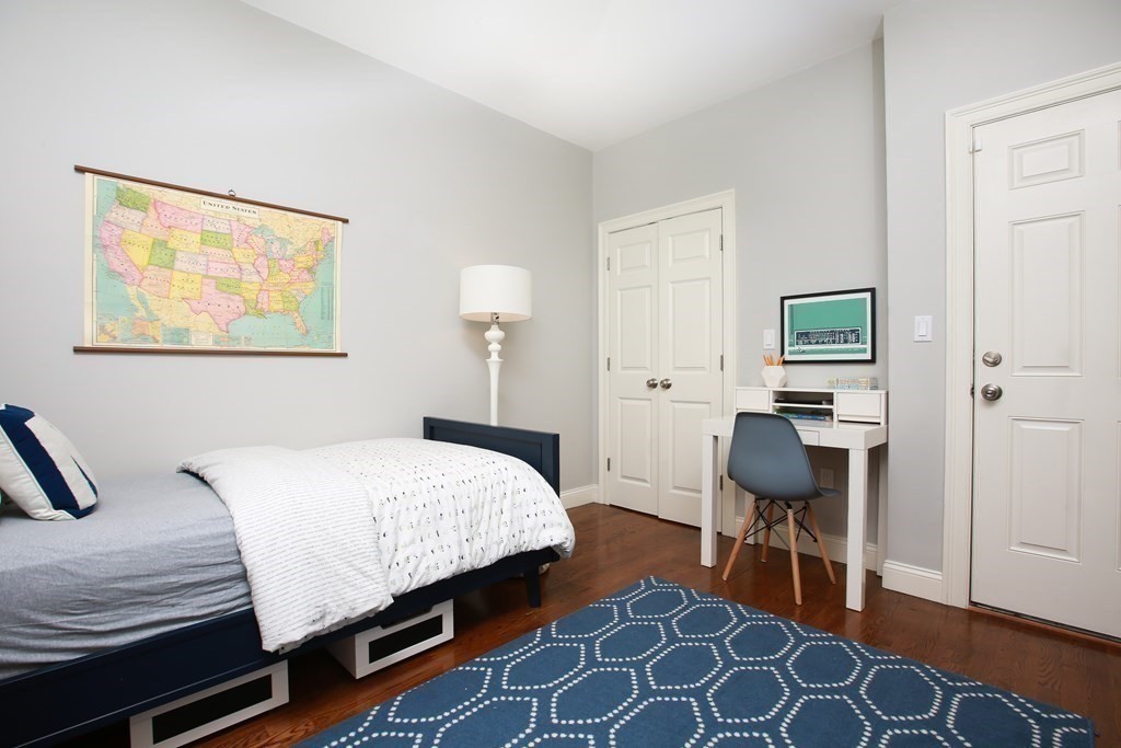 62 Sullivan Street, Unit 1 Boston, MA 02129 - Photo 8 of 11 a bedroom with a bed and a table in it