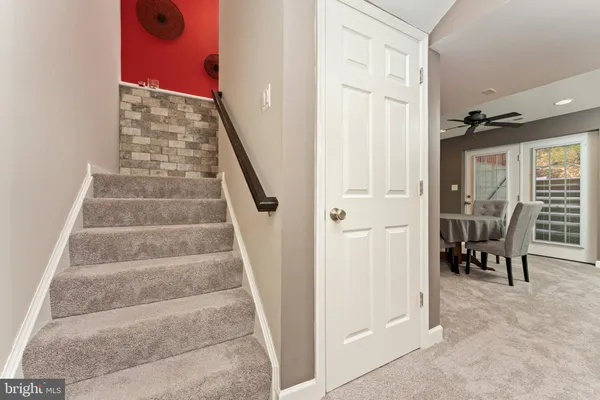 a view of staircase with white walls and furniture