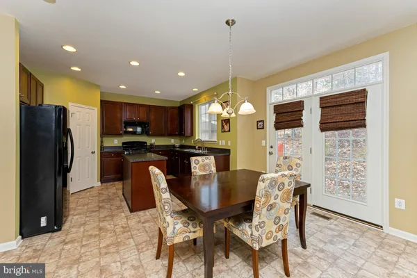 a kitchen with stainless steel appliances kitchen island granite countertop a refrigerator and a stove top oven