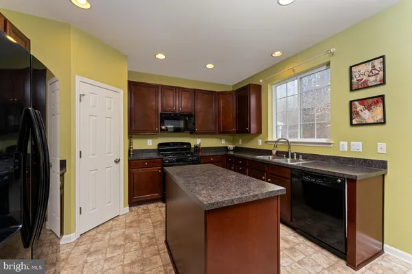 a kitchen with stainless steel appliances granite countertop a stove refrigerator and a sink