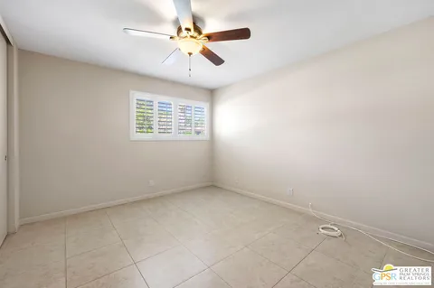 an empty room with a window and a fan