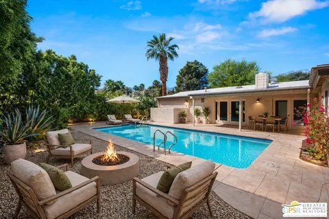 a view of a house with pool and chairs
