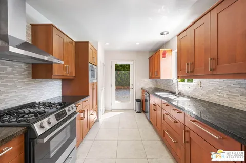 a kitchen with stainless steel appliances granite countertop a stove a sink dishwasher and a refrigerator