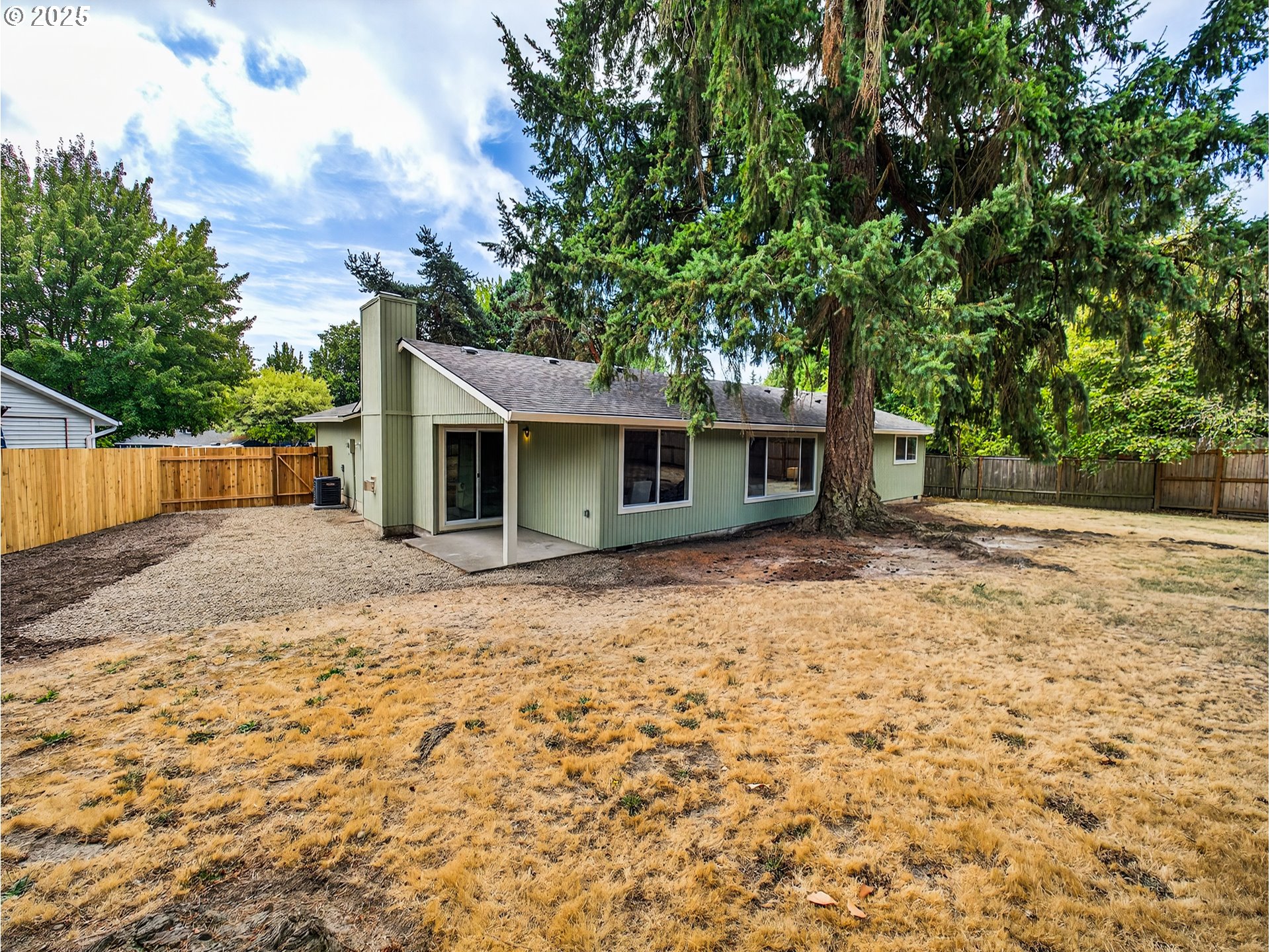 12945 Southwest Hackamore Court Beaverton, OR 97008 - Photo 37 of 48 a backyard of a house with large trees and brick walls