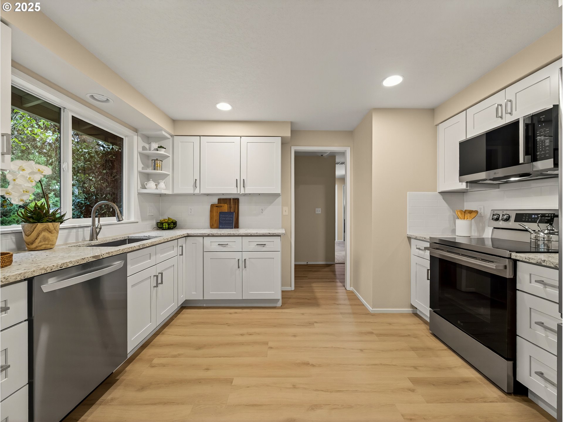 12945 Southwest Hackamore Court Beaverton, OR 97008 - Photo 9 of 48 a kitchen with stainless steel appliances a stove sink microwave and cabinets