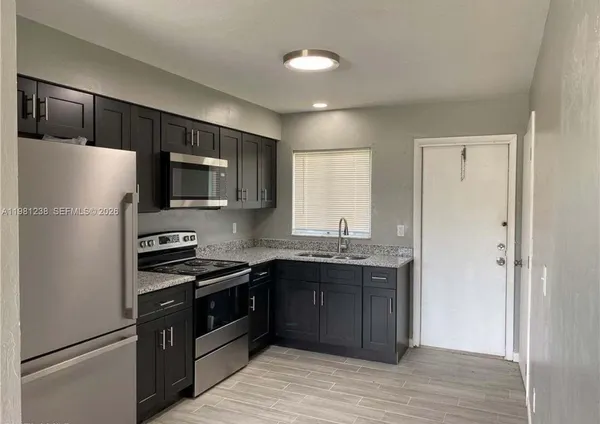 a kitchen with a refrigerator sink and cabinets
