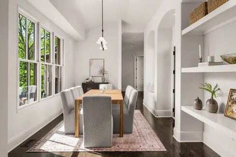 a dining room with table chairs and wooden floor