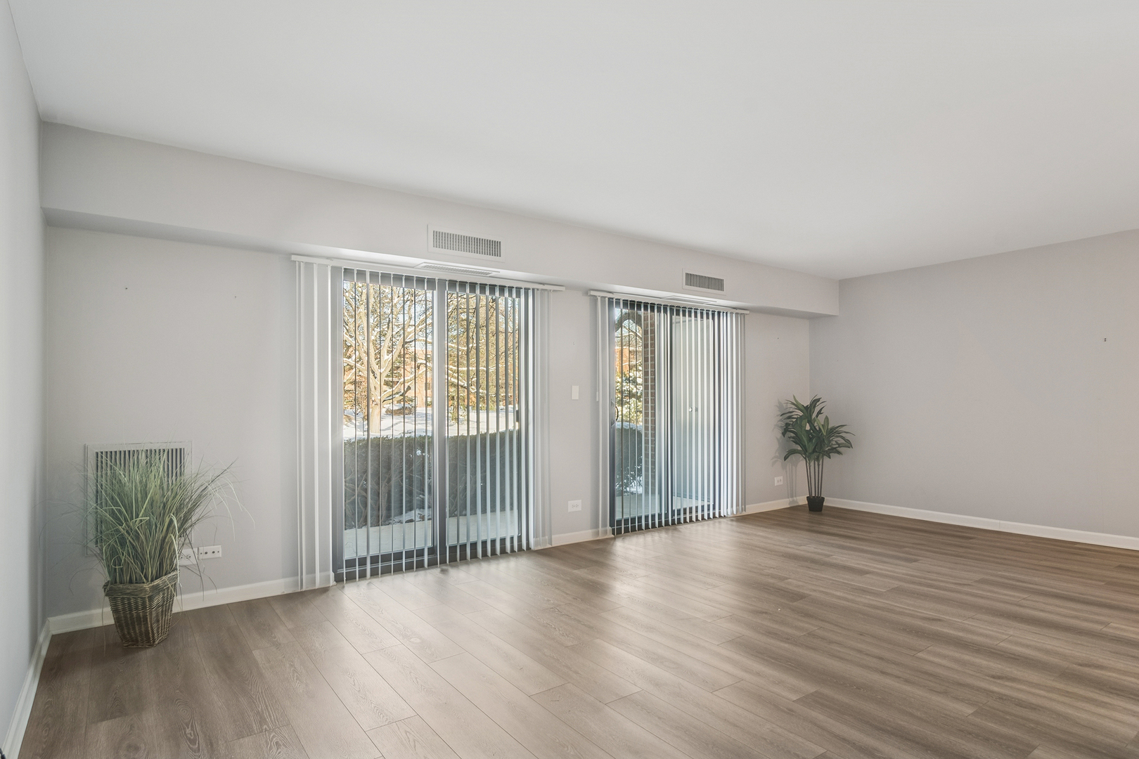1605 East Central Road, Unit 111B Arlington Heights, IL 60005 - Photo 12 of 26 a view of an empty room with wooden floor and a window