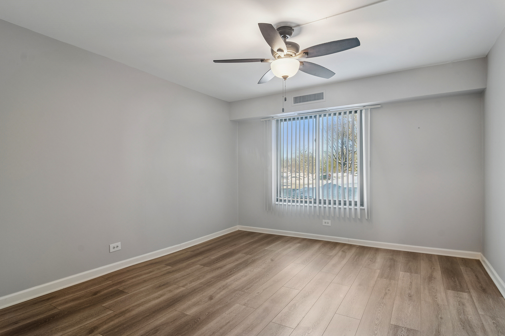 1605 East Central Road, Unit 111B Arlington Heights, IL 60005 - Photo 14 of 26 an empty room with wooden floor and windows