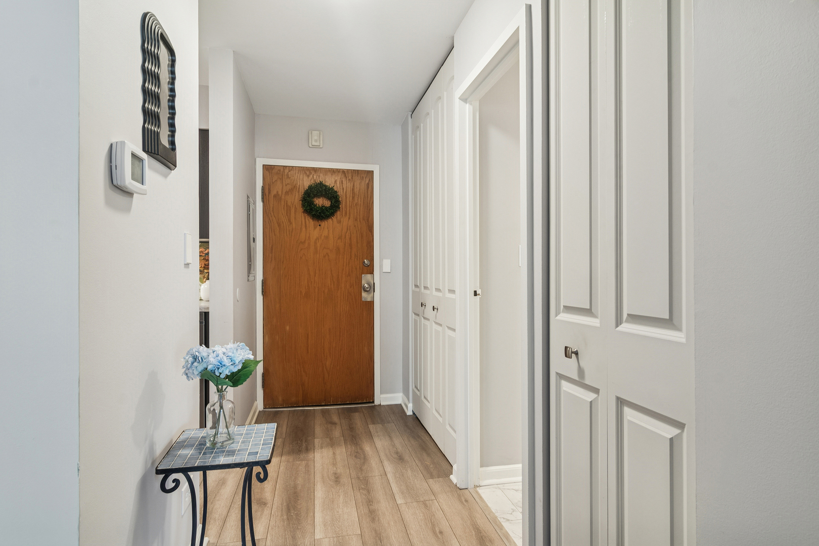 1605 East Central Road, Unit 111B Arlington Heights, IL 60005 - Photo 16 of 26 a view of a hallway with wooden floor and a dining room