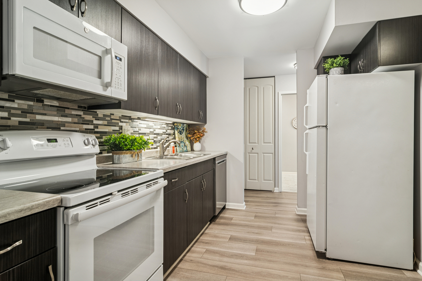 1605 East Central Road, Unit 111B Arlington Heights, IL 60005 - Photo 6 of 26 a kitchen with stainless steel appliances a stove microwave and cabinets