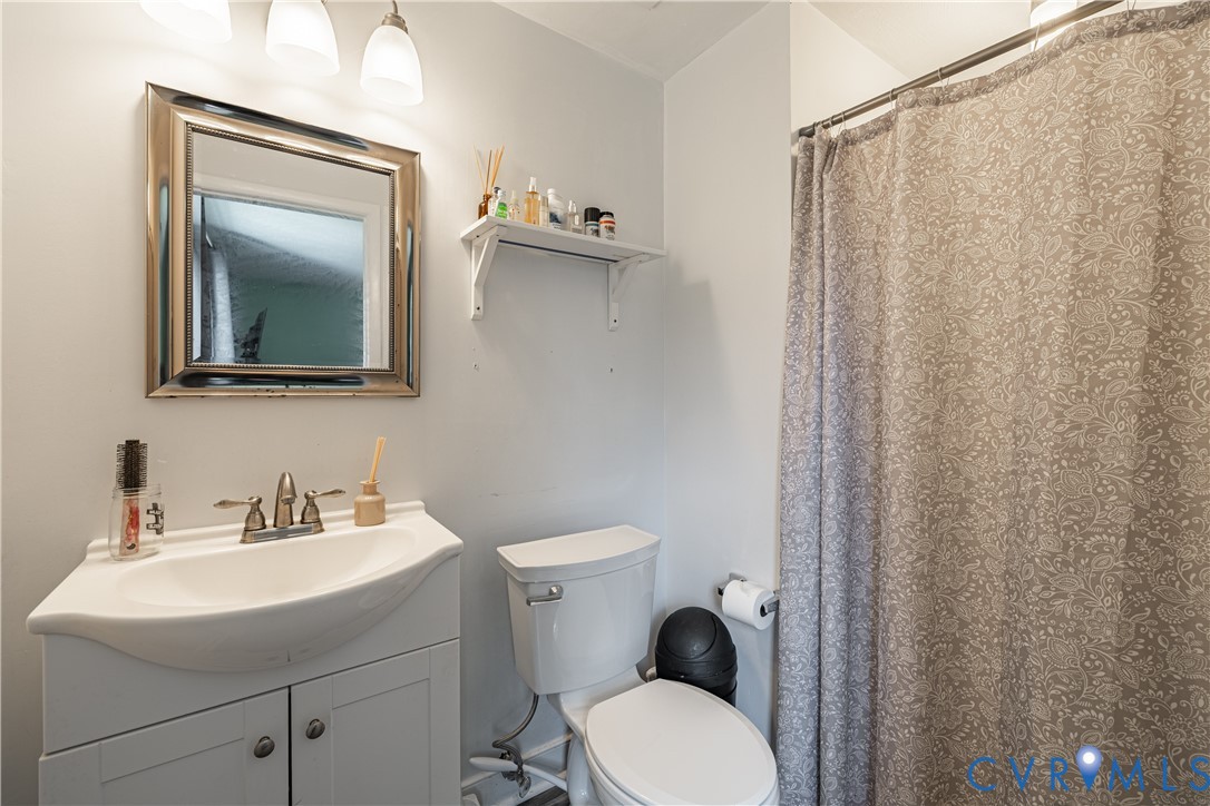 6310 Dahlia Road Mechanicsville, VA 23111 - Photo 11 of 38 a bathroom with a toilet a sink and a mirror
