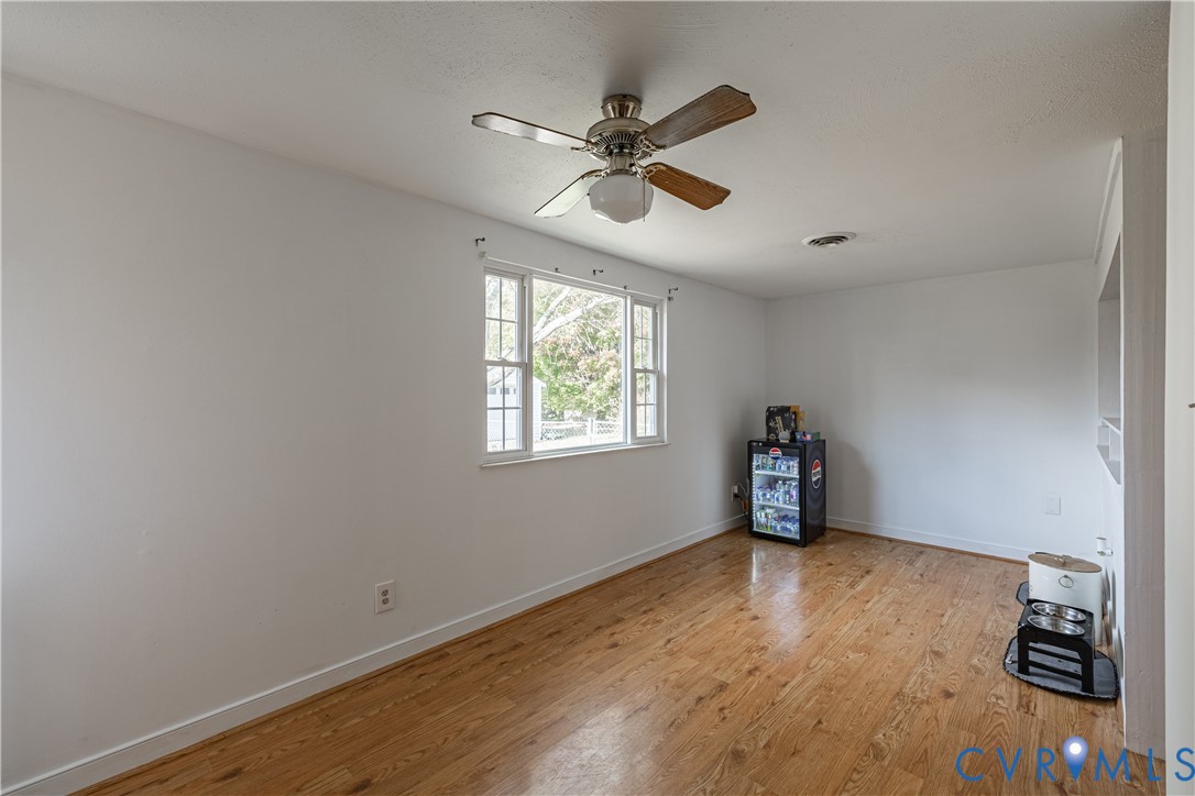 6310 Dahlia Road Mechanicsville, VA 23111 - Photo 19 of 38 an empty room with wooden floor fan and windows