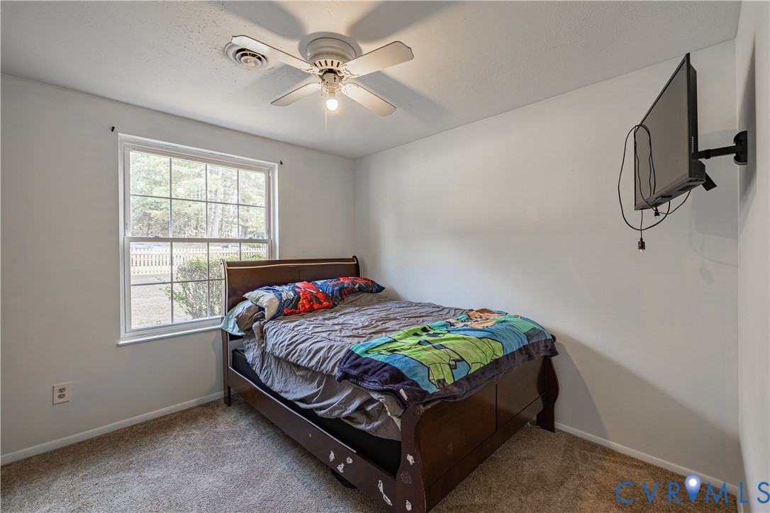 6310 Dahlia Road Mechanicsville, VA 23111 - Photo 7 of 38 a bed sitting in a bedroom next to a window