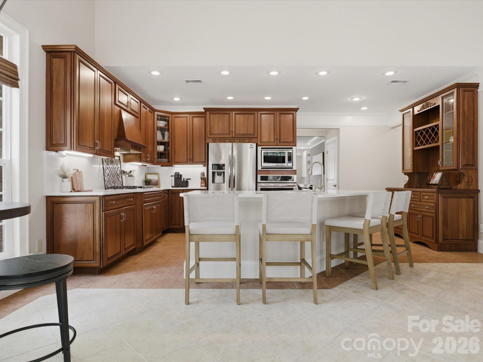 809 Savile Lane Fort Mill, SC 29715 - Photo 16 of 48 a kitchen with stainless steel appliances kitchen island granite countertop a table chairs sink and cabinets