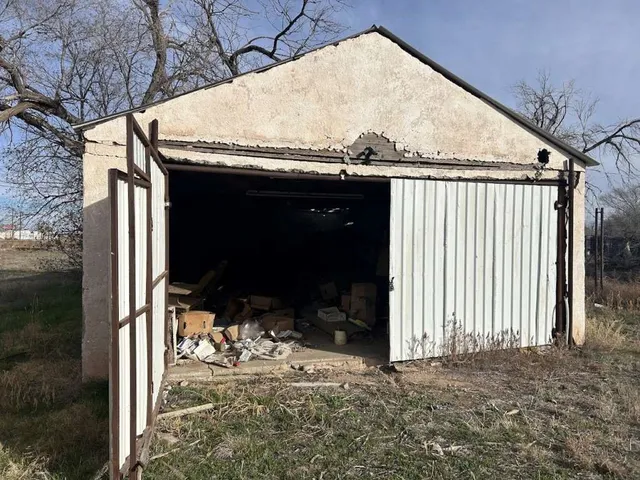 a view of dirt field with large trees