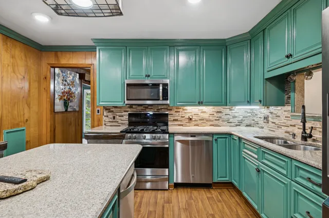 a kitchen with a table chairs refrigerator and microwave