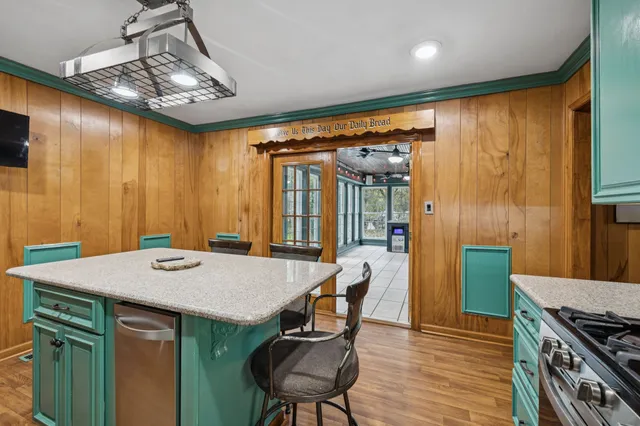 a kitchen with stainless steel appliances a table chairs refrigerator and microwave