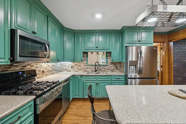 a view of a livingroom with wooden floor and a chandelier