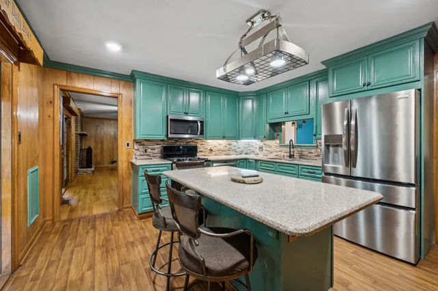 a view of a livingroom with wooden floor and a ceiling fan