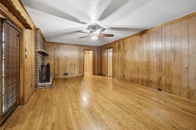 a view of an empty room with a fireplace and a window