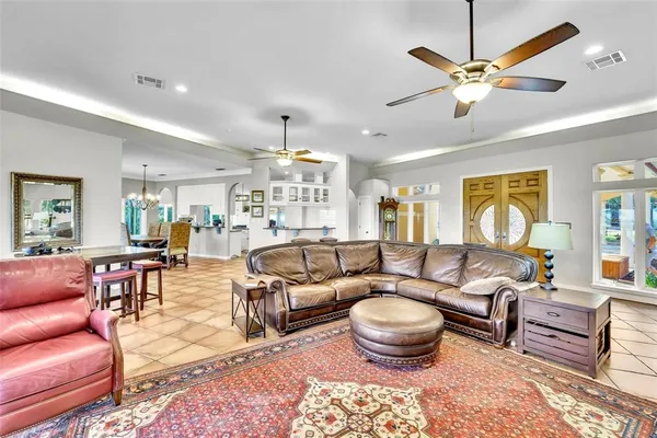a living room with furniture a chandelier and a dining table