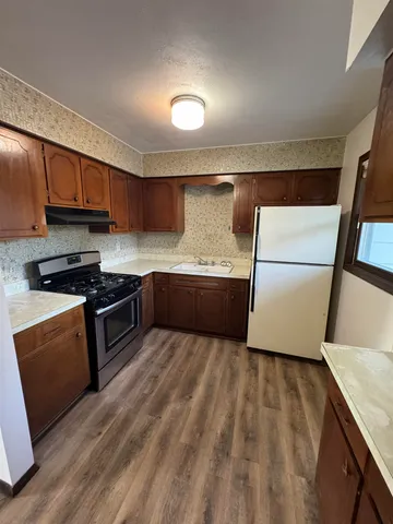 a kitchen with stainless steel appliances granite countertop a refrigerator a sink and a stove