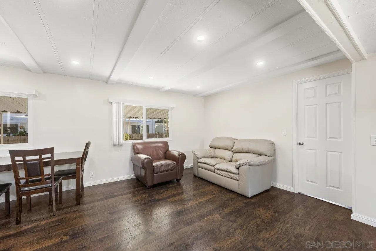 900 Howard Avenue, Unit 54 Escondido, CA 92029 - Photo 12 of 25 a living room with furniture and a dining table with wooden floor