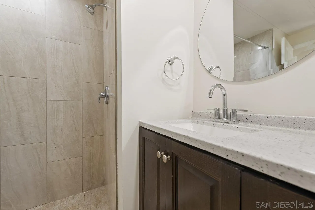 900 Howard Avenue, Unit 54 Escondido, CA 92029 - Photo 17 of 25 a bathroom with a granite countertop sink a mirror and shower