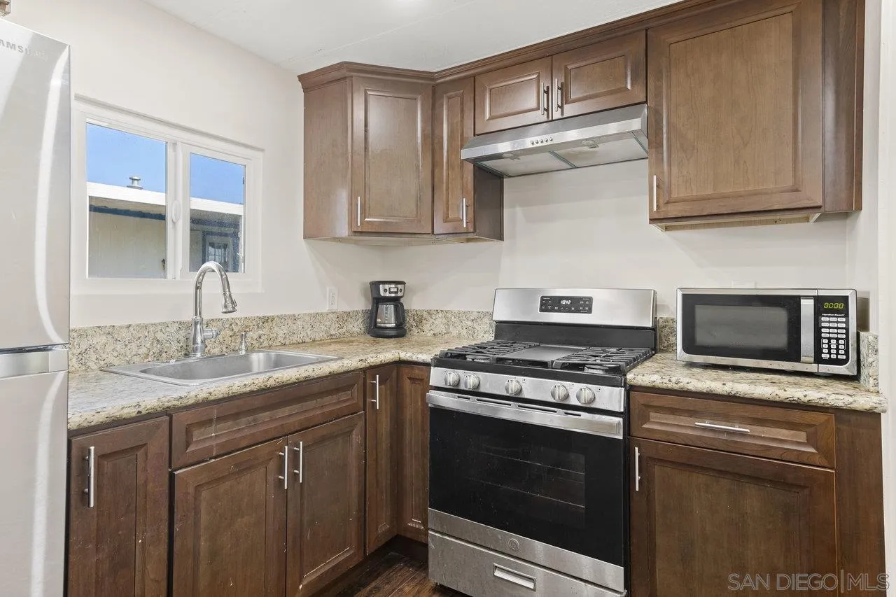 900 Howard Avenue, Unit 54 Escondido, CA 92029 - Photo 9 of 25 a kitchen with stainless steel appliances granite countertop a stove microwave and cabinets