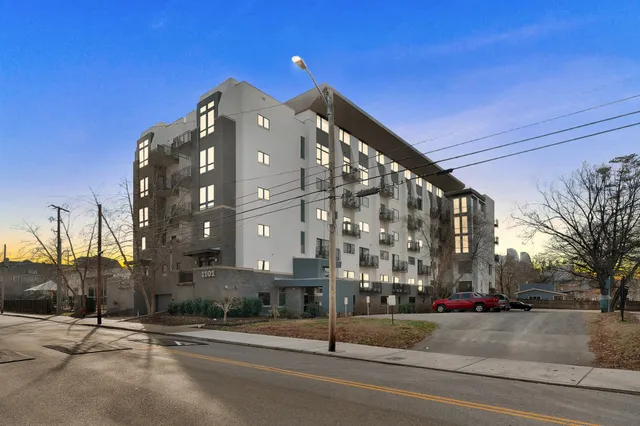 a view of a tall building next to a road
