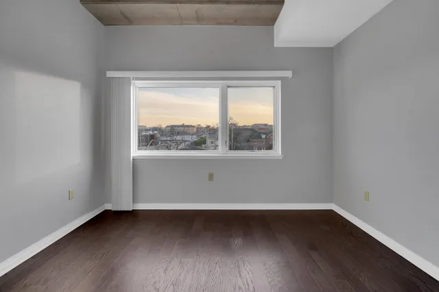 a view of a room that has wooden floor and large window