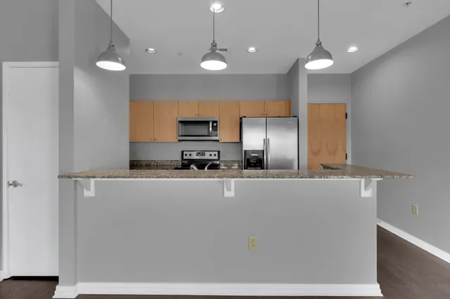 a kitchen with stainless steel appliances a refrigerator sink and microwave