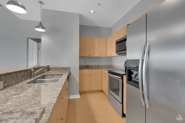 a kitchen with stainless steel appliances granite countertop a sink stove and refrigerator
