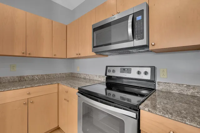a kitchen with wooden cabinets and a stove top oven