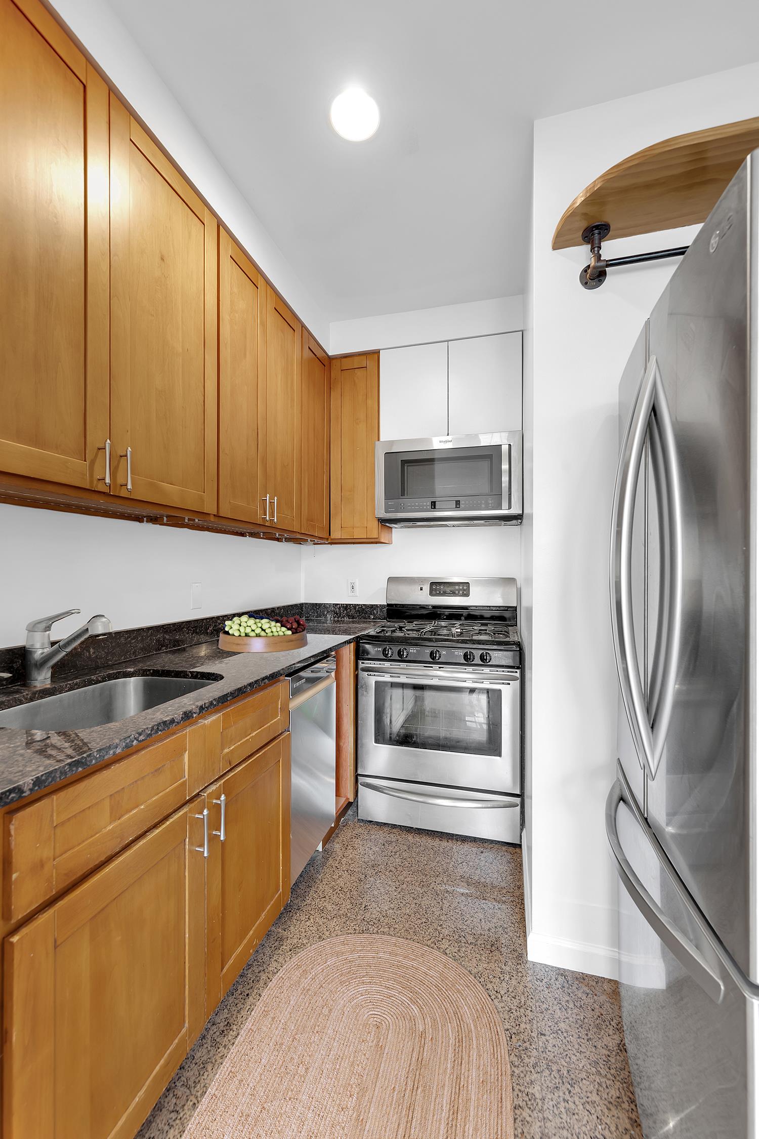 30-63 32nd Street, Unit 3B Queens, NY 11102 - Photo 5 of 12 a kitchen with granite countertop a stove and a refrigerator