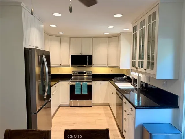 a kitchen with stainless steel appliances a stove sink microwave and refrigerator