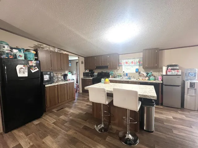a kitchen with a table chairs refrigerator and cabinets