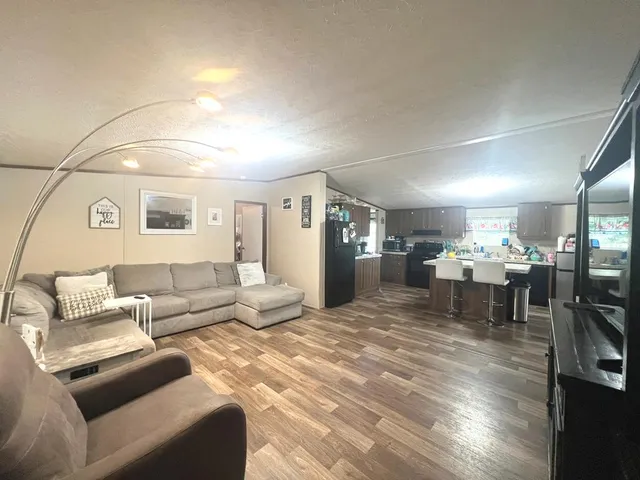 a living room with furniture and a dining table with kitchen view