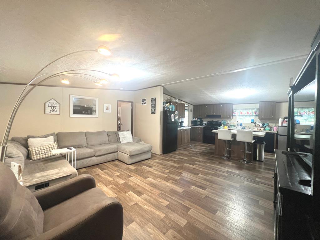 138 3rd Street Harper, TX 78631 - Photo 7 of 32 a living room with furniture and a dining table with kitchen view