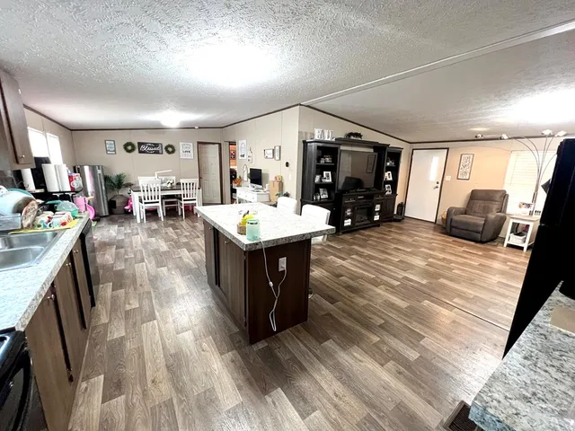 a large living room with stainless steel appliances granite countertop furniture and a kitchen view
