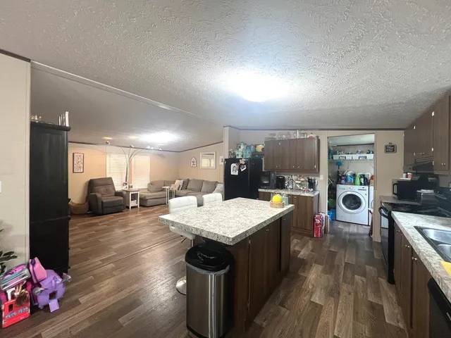 a open kitchen with stainless steel appliances granite countertop a stove oven and a refrigerator with cabinets