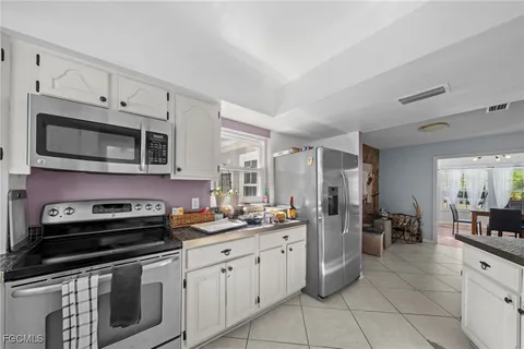 a kitchen with stainless steel appliances a stove a sink cabinets and a microwave