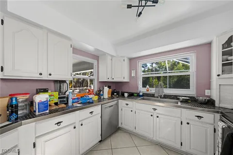 a kitchen with cabinets appliances a sink and a window